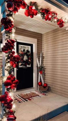 the front door is decorated with christmas ornaments and lights, including red baubies