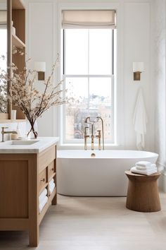 a bathroom with a tub, sink and window