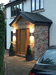 a car parked in front of a house with lights on it's side door