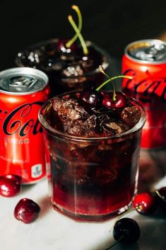 two cans of coca cola and some cherries