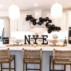 a kitchen filled with lots of food and balloons in the shape of nye letters