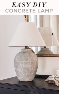 a lamp sitting on top of a table next to a dresser and mirror with text overlay that reads easy diy concrete lamp