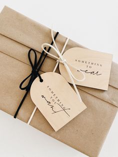 two brown envelopes tied with black string and paper tags that say something to me