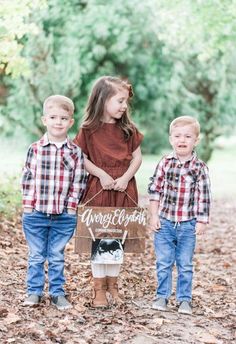 three young children standing next to each other in the woods