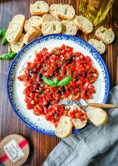 a blue and white plate topped with rice covered in tomato sauce next to bread slices