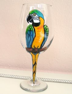 a glass with a colorful parrot painted on it