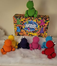 the crocheted toys are lined up in front of the nerdys box