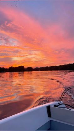 the sun is setting on the water as seen from a boat