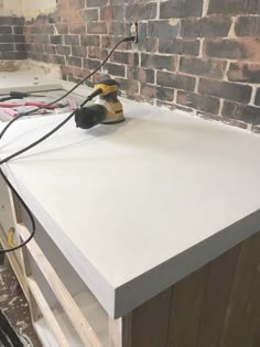 a workbench with tools on top of it in front of a brick wall