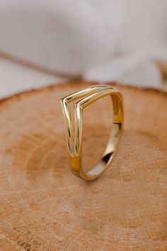 a gold ring sitting on top of a piece of wood