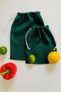 a green bag with fruit and vegetables next to it