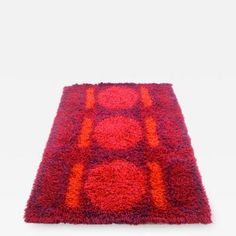 a red and orange rug with circles on it's sides, against a white background