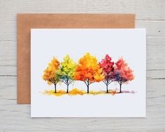 a card with watercolor trees on it