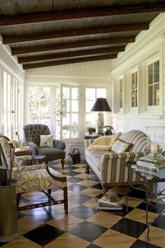 a living room filled with furniture and lots of windows