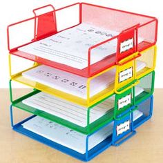 a stack of colorful file folders sitting on top of a wooden table