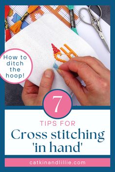 a hand is stitching on a piece of fabric with scissors and thread in the background