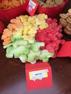 a table topped with lots of different colored candies and cookies next to each other