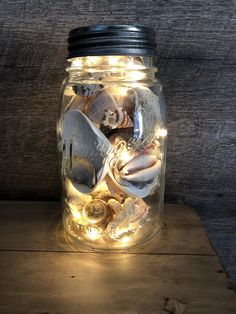 a mason jar filled with seashells and lights