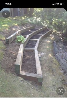 an outdoor garden area with raised wooden planters and plants growing out of the ground