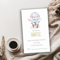 a cup of coffee next to a card with an image of a bear in a hot air balloon