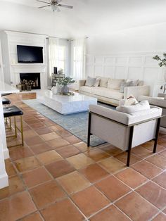 a living room filled with furniture and a flat screen tv mounted on the wall over a fireplace