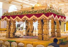 an elaborately decorated stage set up for a wedding ceremony with white and gold decor