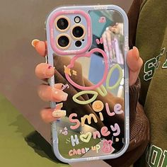 a woman holding up her phone case with the words smile and honey on it in front of her face