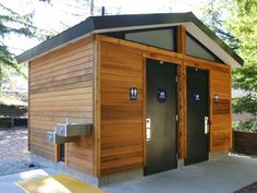 a small wooden building with two black doors