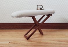 a small ironing board on top of a hard wood floor