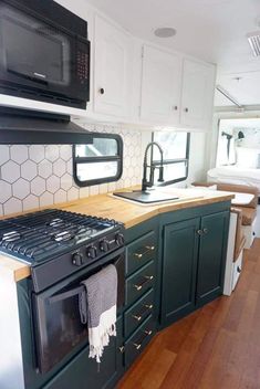 a kitchen area with an oven, microwave and stove top in a recreational mobile home