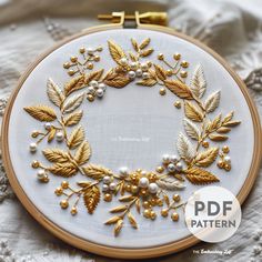 an embroidered wreath with gold leaves and pearls