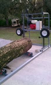 a large tree being worked on by a machine in a yard with two tires attached to it