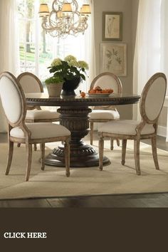 a dining room table with white chairs and a potted plant on top of it