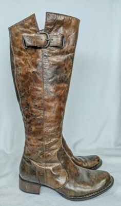 a pair of brown boots sitting on top of a white background