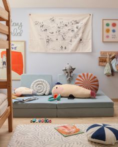 a child's room with toys and artwork on the wall