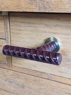 a close up of a door handle on a wooden cabinet