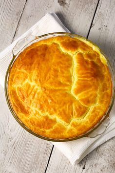 a pie sitting on top of a wooden table next to a white napkin and fork