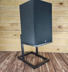 a black speaker sitting on top of a wooden floor