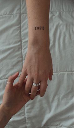 two hands holding each other with the number twenty on their wrist