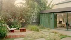 an outdoor area with grass, plants and stepping stones on the ground in front of a house