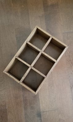 an empty wooden box sitting on top of a hard wood floor