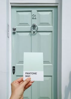 a person holding up a pantone sign in front of a door