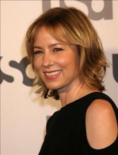 a close up of a person wearing a black dress and smiling at the camera with a smile on her face