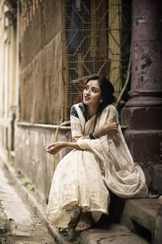 a woman sitting on the side of a building