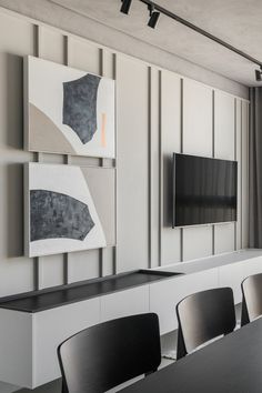 an empty conference room with black chairs and a flat screen tv mounted on the wall