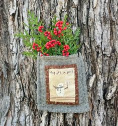 a potted planter on the side of a tree with red flowers in it