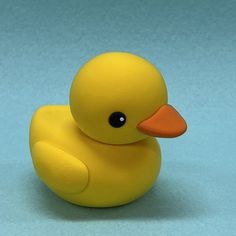 a yellow rubber duck sitting on top of a blue surface with its head turned to the side