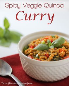 a white bowl filled with food on top of a red cloth next to a spoon