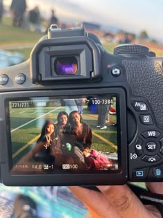 a person is holding up a camera to take a photo with two women on the field