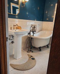 a bathtub and sink in a bathroom with stars painted on the wall behind it